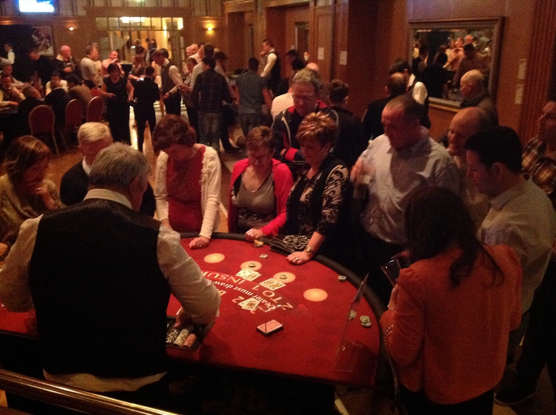 Guests gathered around a Crazy Vegas casino table at an evening event