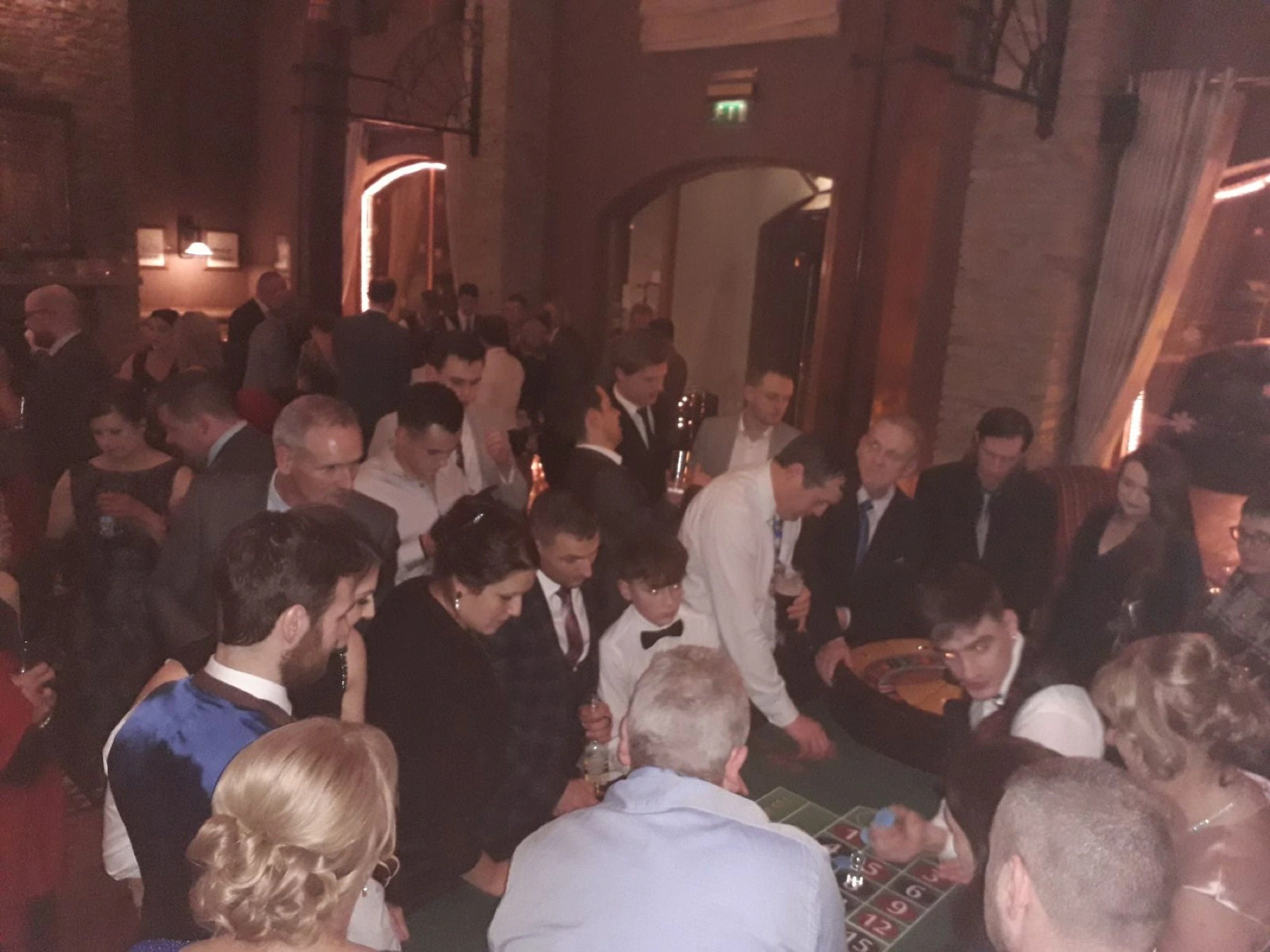 Guests gathered around casino tables at an evening reception